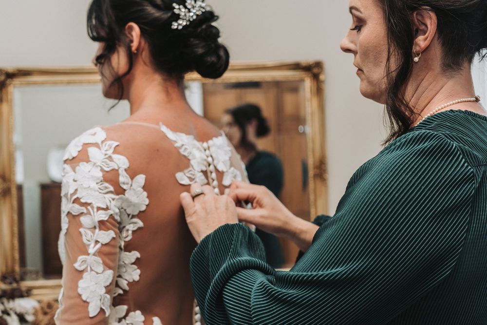Pother of the bride buttoning the bride's wedding dress, Dublin, Ga