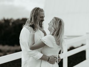 Romantic couple in white outfits sharing an intimate moment against a light background. Black and White Photography. Timeless love stories.