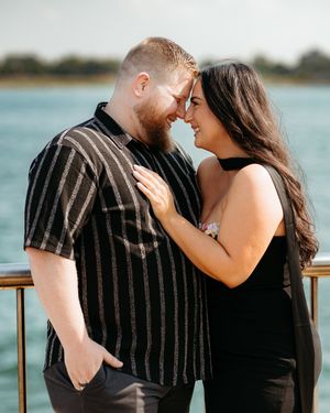 Romantic Detroit waterfront portrait of couple in black outfits sharing intimate moment. Candid documentary photography. Engagement session.