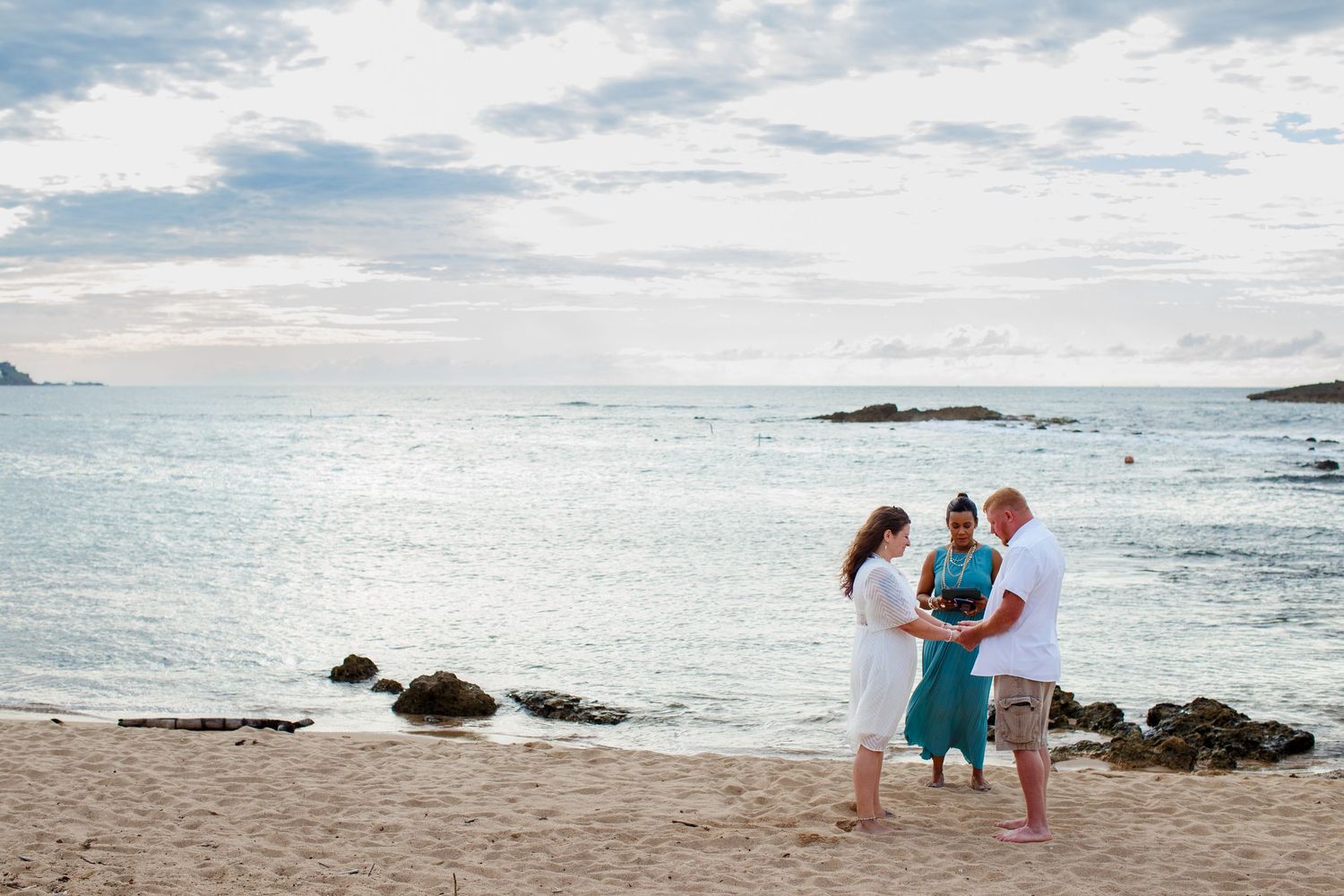 Elopement on the beach at Balneario del Escambrón in Old San Juan, Puerto Rico. Wedding ceremony. Bride, groom, and officiant.