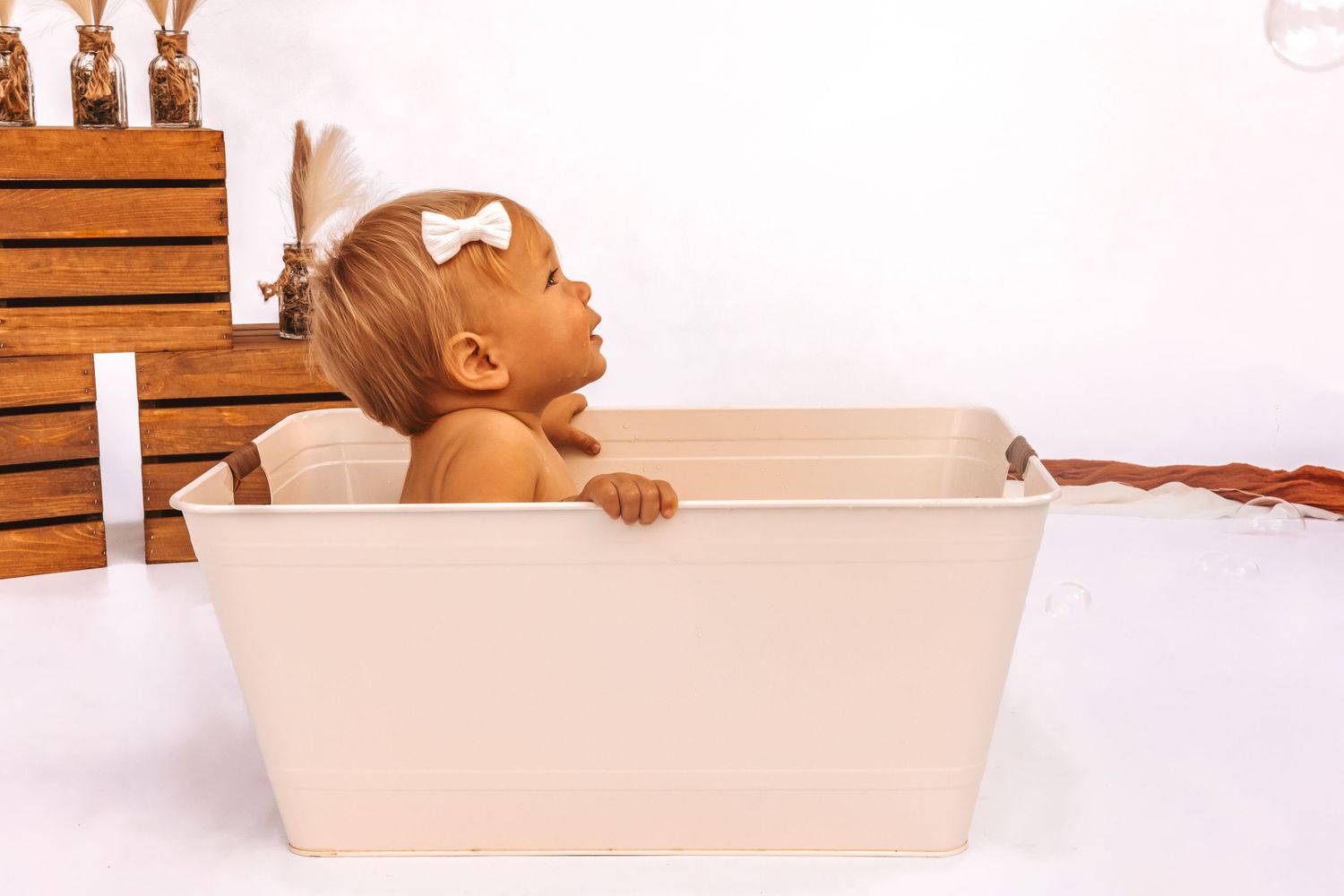 Baby bath time photography series in white vintage tub setting.