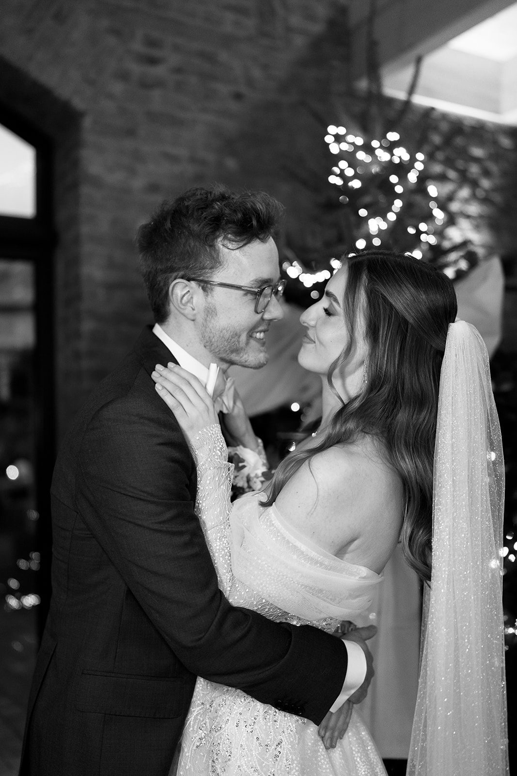 Intimate wedding kisses captured in sequence against a brick wall with twinkling lights.