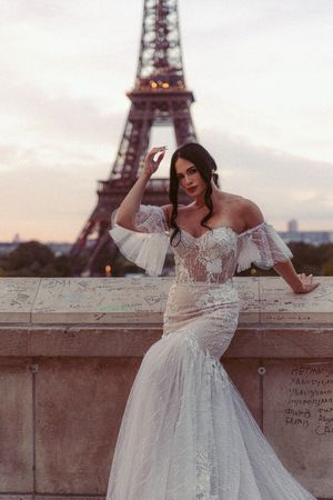 Romantic wedding photography featuring a lace gown near the iconic Eiffel Tower at dusk.