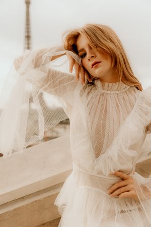 Dreamy fashion photography of a flowing white tulle dress against a minimalist light background.