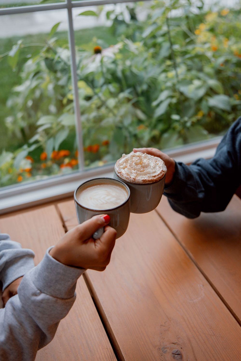 Sequence of four cropped photos showing hands holding coffee cups with latte art against a sunlit window backdrop.