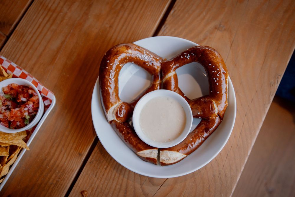 Plate of spicy buffalo chicken wings with blue cheese dipping sauce served on a wooden table.