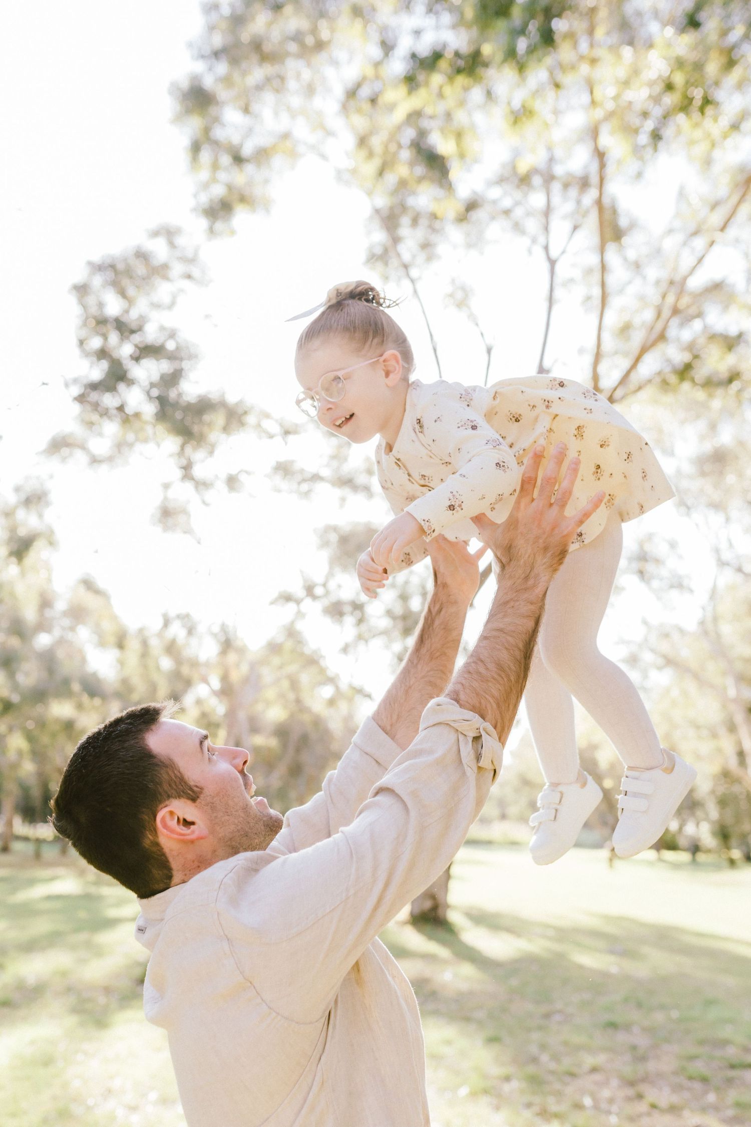 A series of candid shots showing tender moments between father and child playing together in a sunlit outdoor setting.