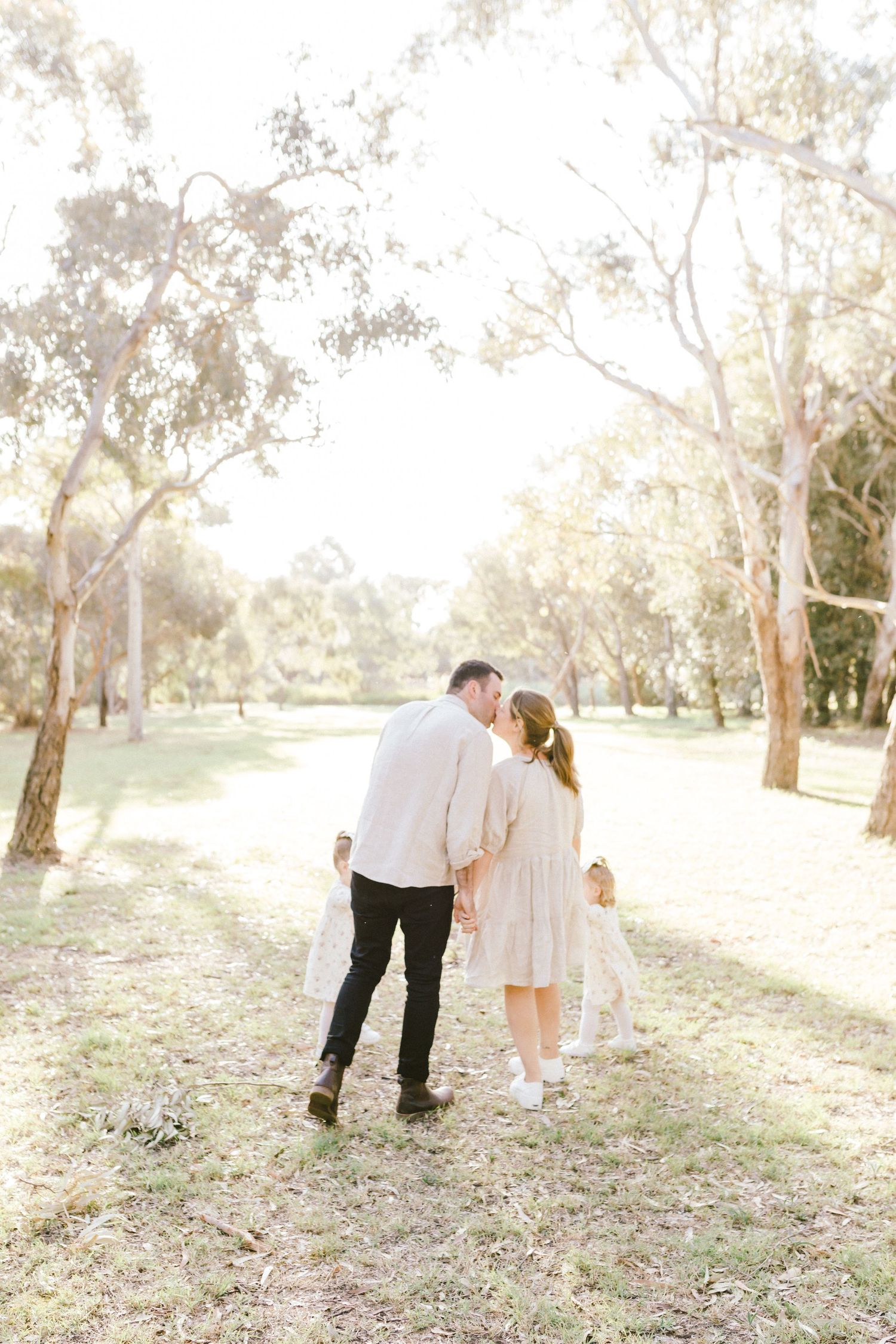 Candid family moments captured in a dreamy eucalyptus forest setting with soft natural lighting.
