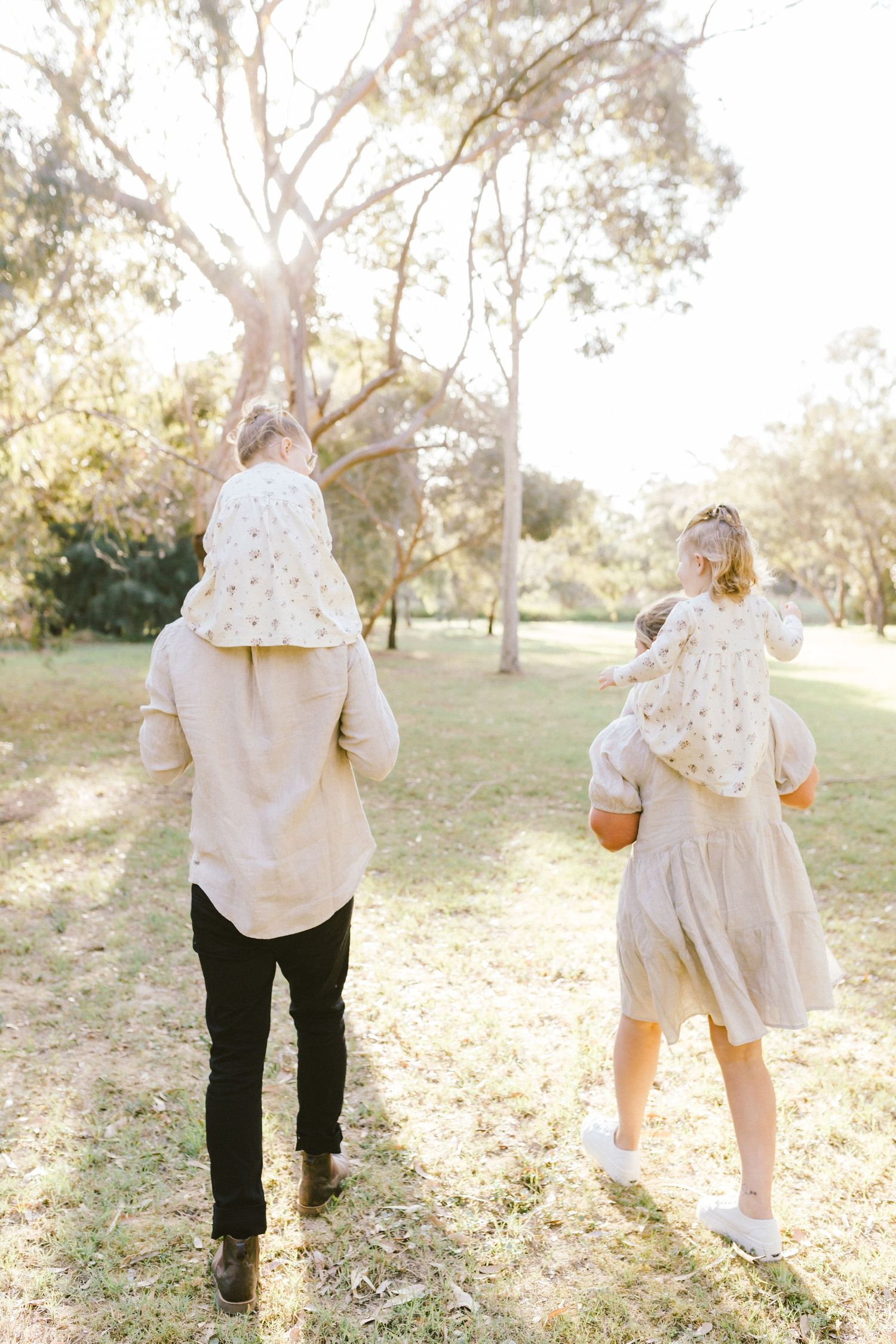 Four sequential images showing a couple walking together in a sunlit park with golden afternoon light filtering through trees.