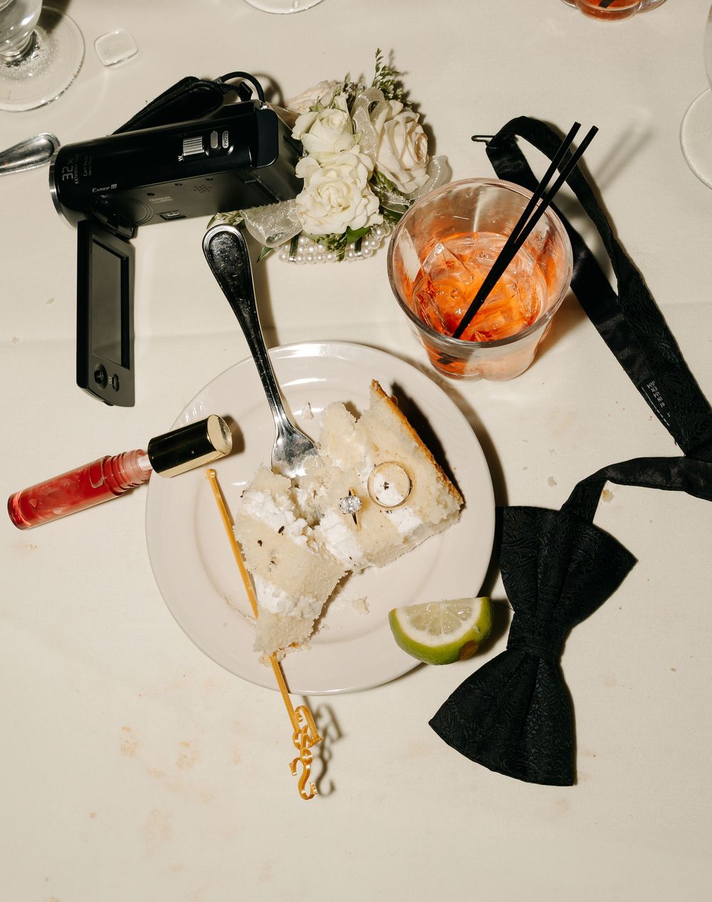 Scattered cocktail glasses and drinks on a light colored surface with citrus garnishes.