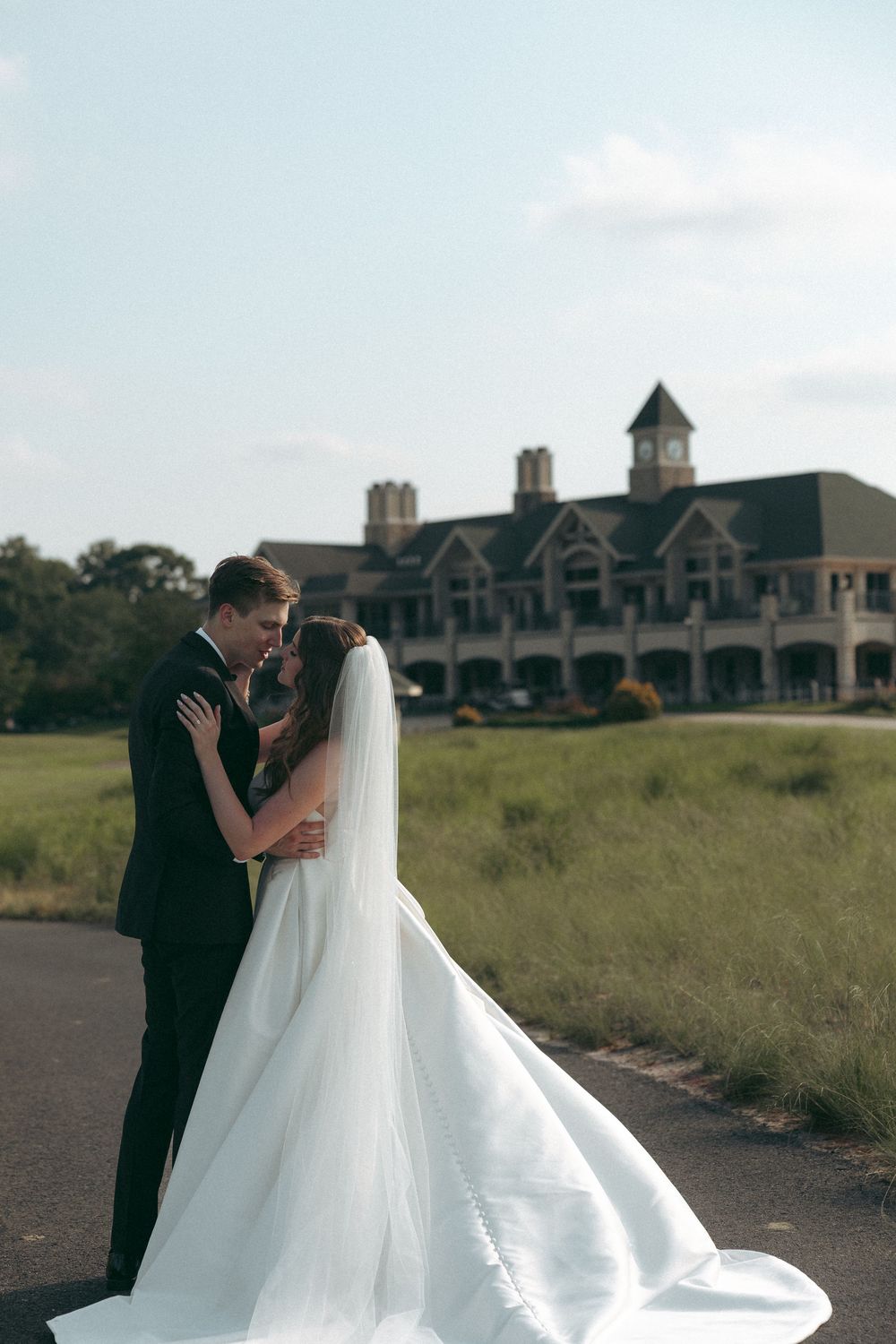 Newlyweds sharing intimate moment with elegant building in background.