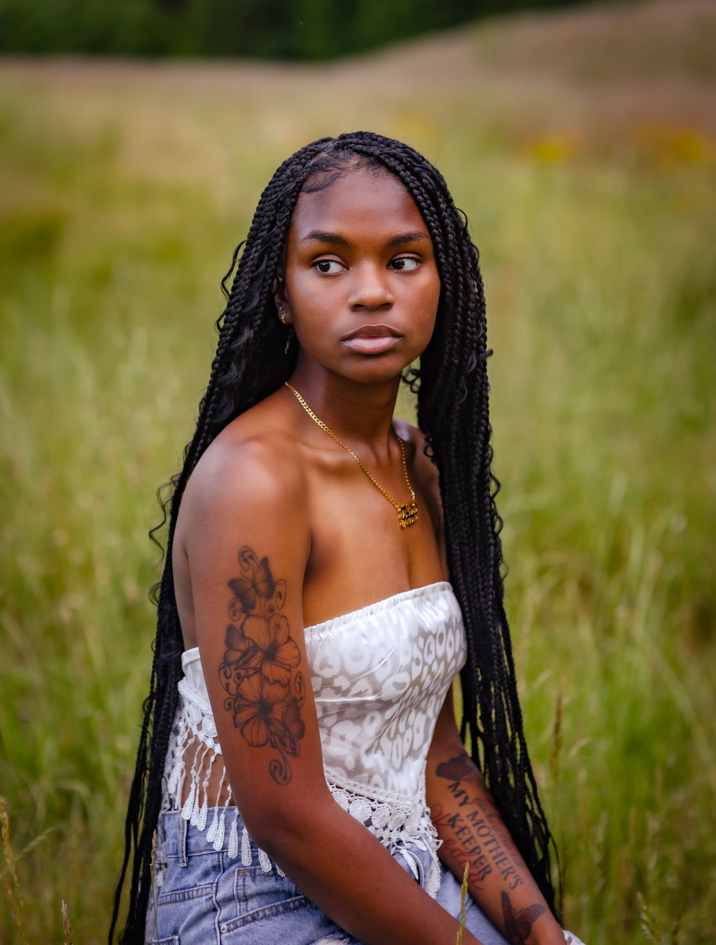 Artistic outdoor portraits in a white dress among tall grass during golden hour.
