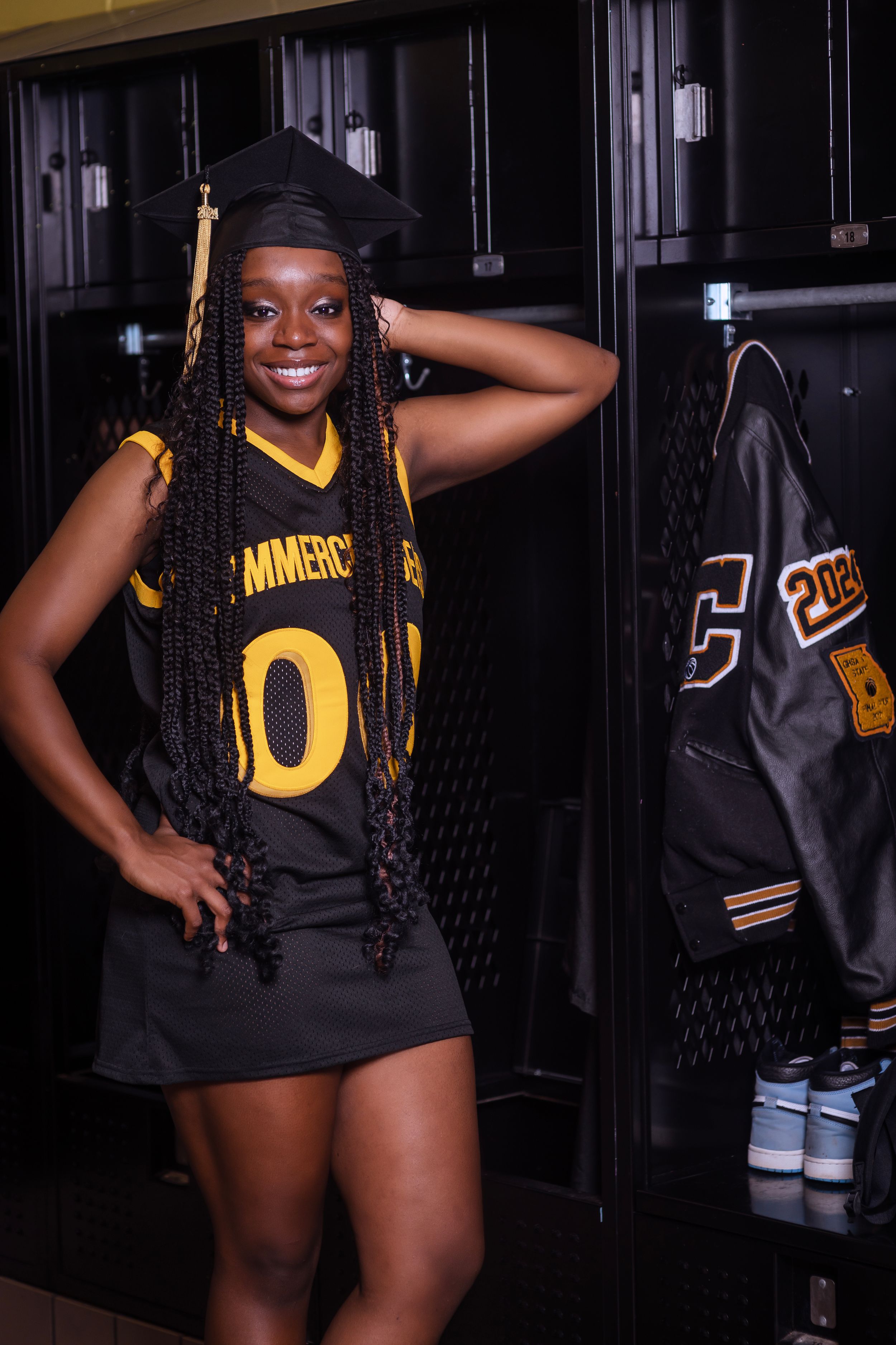 Sports themed photo session in front of lockers featuring a black and gold jersey.