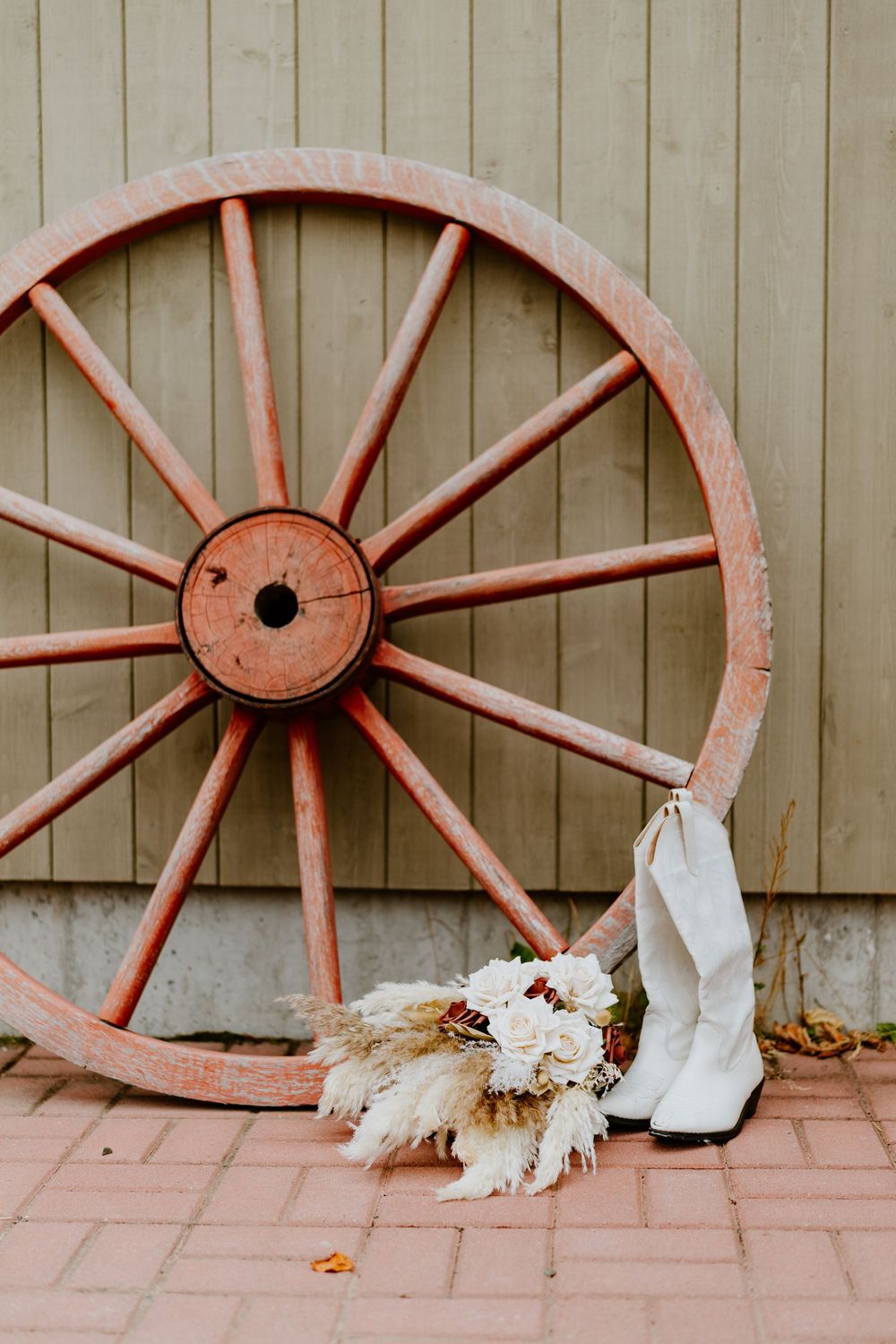 Four sequential photos showing a playful white cat sitting behind vintage spinning wheels on a brick surface.
