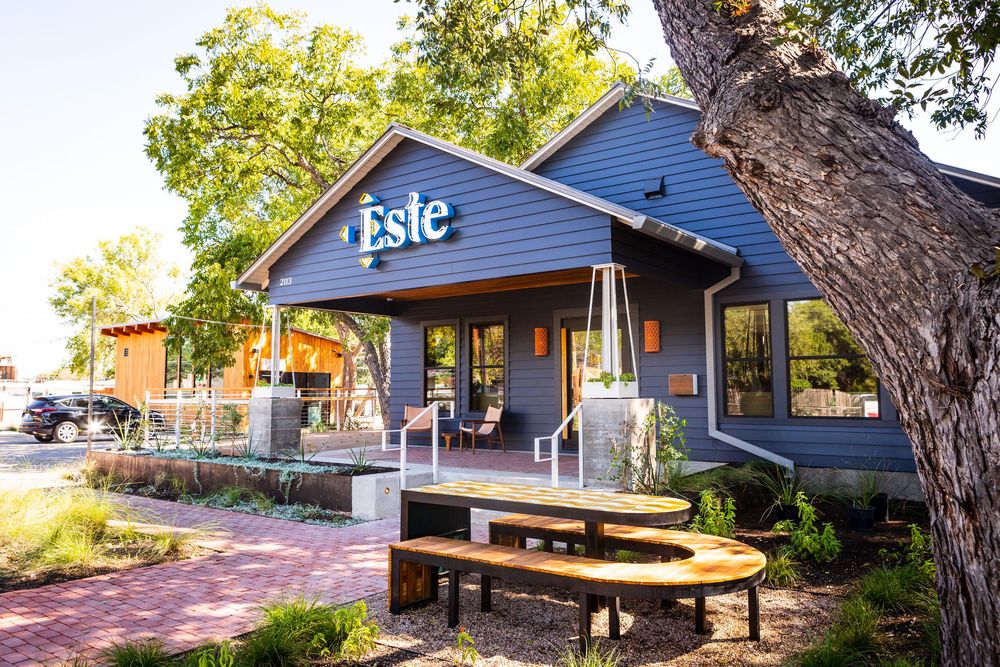 A cozy blue restaurant building with outdoor seating and a sign reading 'Isle' on a sunny afternoon.