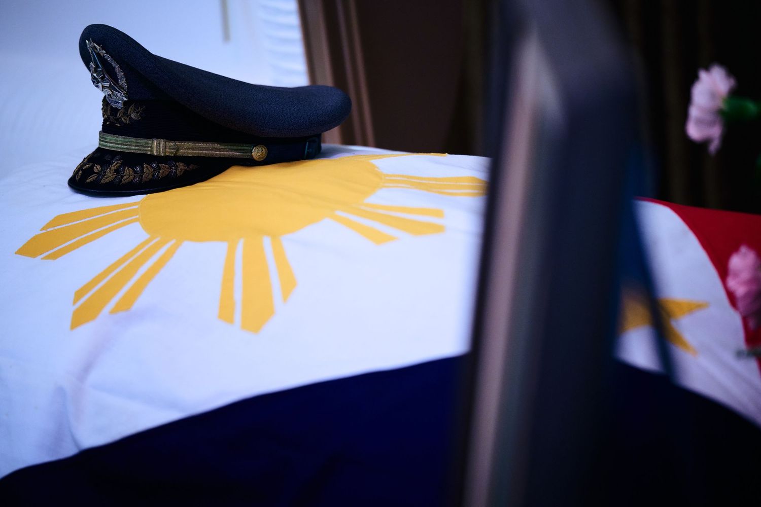 Three Filipino flags with sun and stars design displayed together against a dark background.