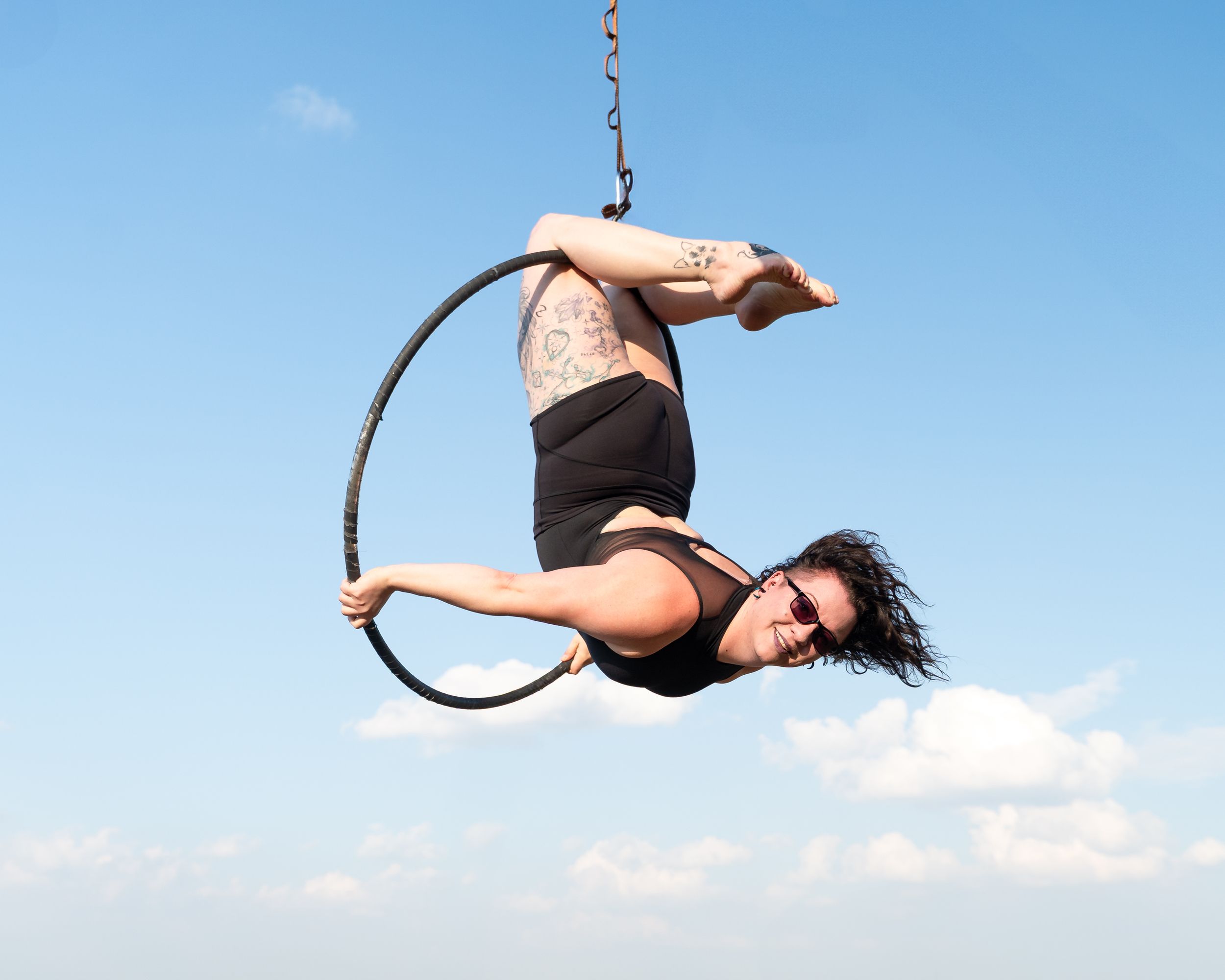 Professional diver performs a graceful backflip sequence against bright blue sky during competition dive.