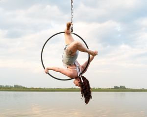 Action shots capture someone doing an aerial flip while swinging from a rope over a peaceful lake.