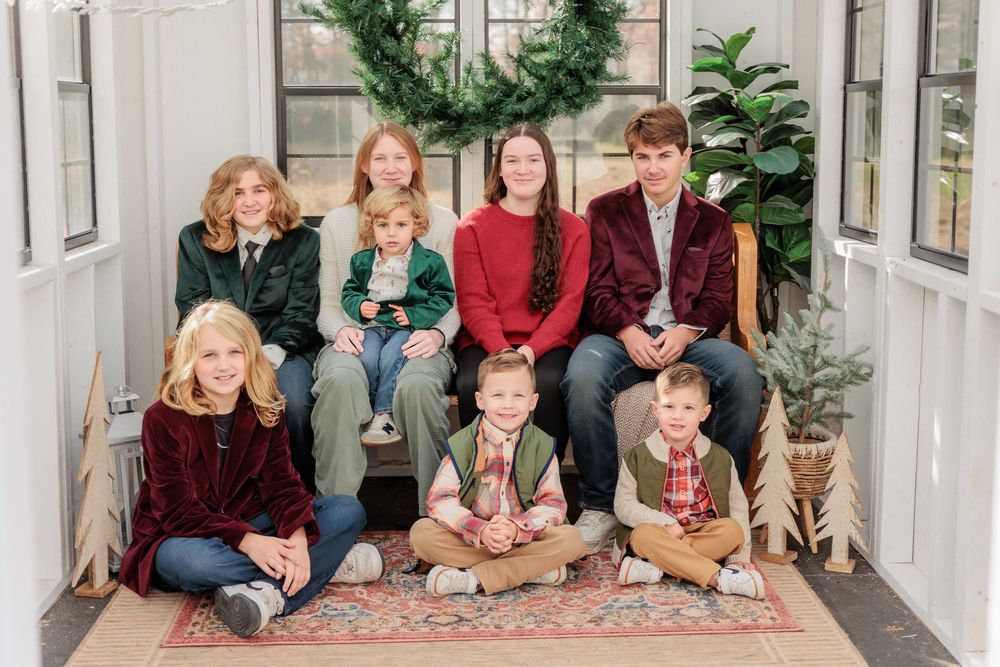 a group sitting on floor in a bright indoor space with greenery and white walls at Turkey Trac Farm in Millville NJ