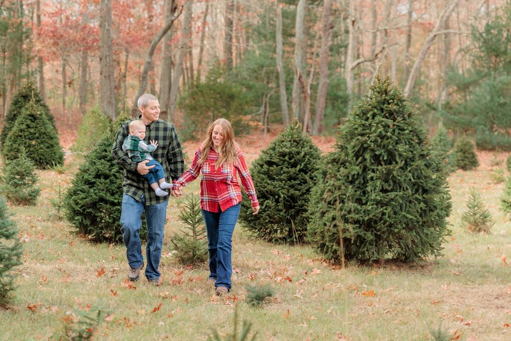 Family shopping together at a local Christmas tree farm on a crisp day, selecting the perfect tree at Turkey Trac Farm in Millville NJ
