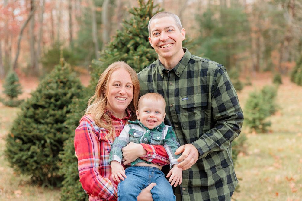 A happy group embracing outdoors at a Christmas tree farm on an sunny day at Turkey Trac Farm in Millville NJ
