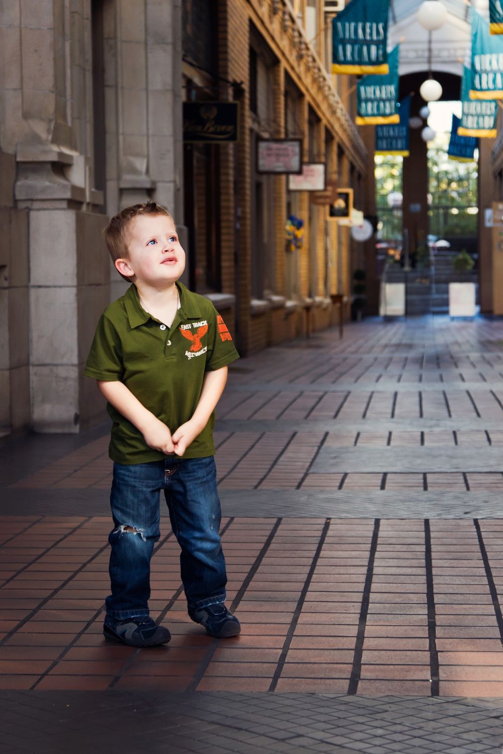 Young boy in arcade; child portrait photography session in downtown Ann Arbor, Michigan.