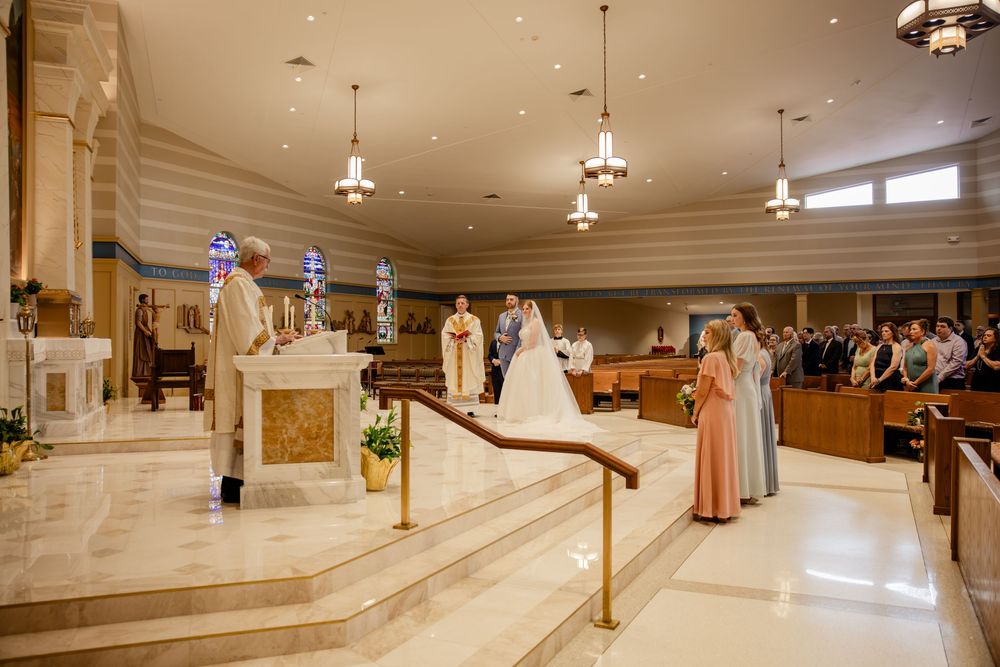 Panoramic view of a grand marble lobby interior with pillars, pendant lights and polished floors.