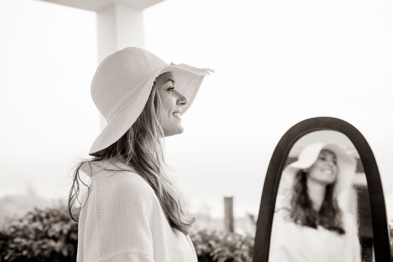 Carefree moment captured in black and white of woman in sunhat looking to the side.