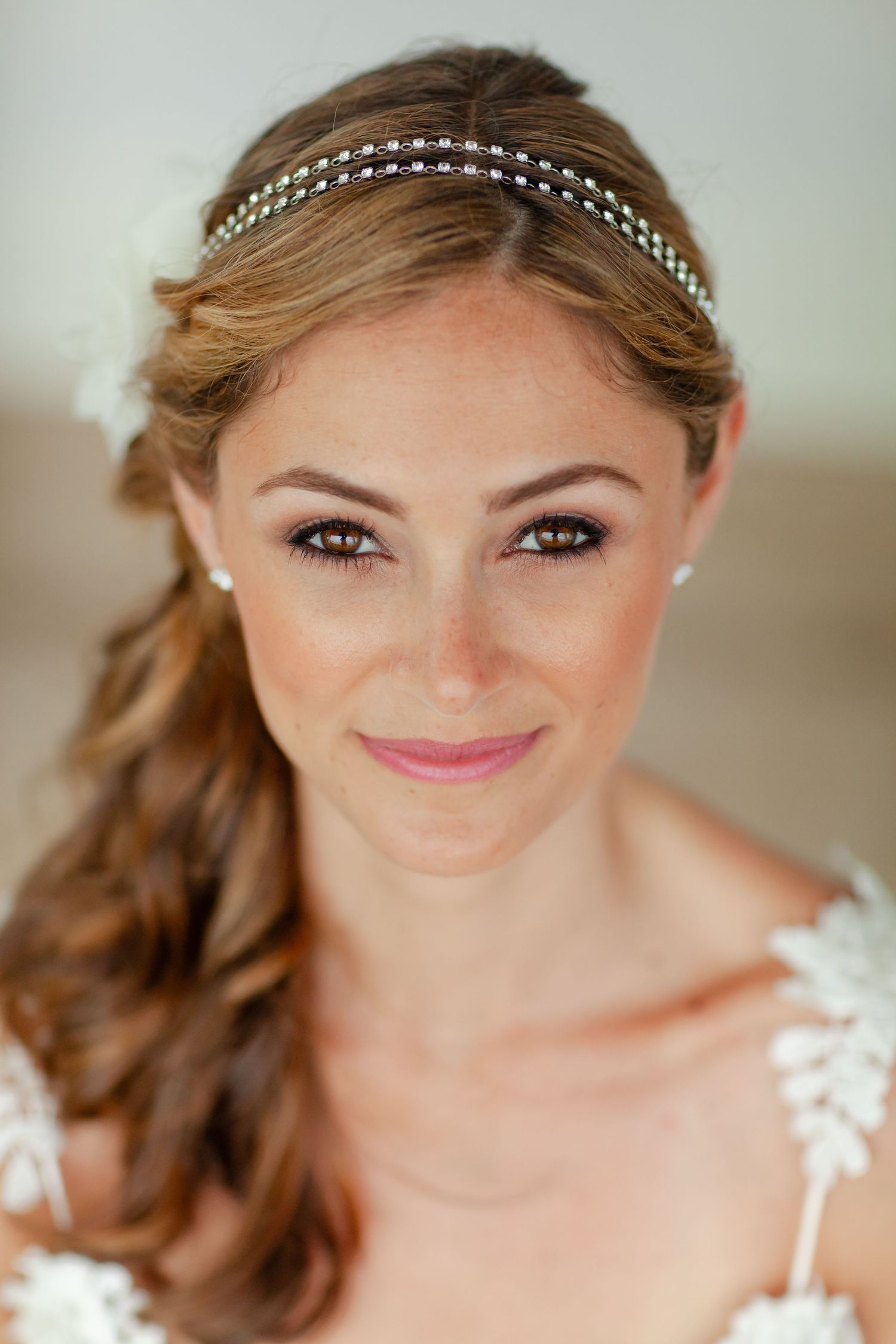 Elegant bridal beauty portrait featuring crystal headband and soft makeup.