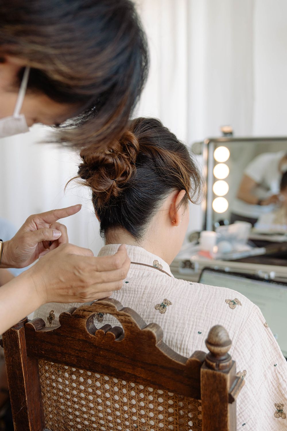 Professional hair styling in progress at a salon with vintage wooden chair.