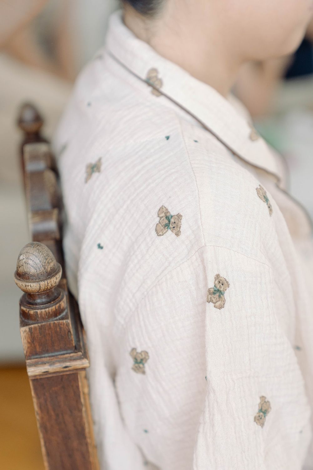 Close-up detail of a delicate butterfly print pattern on a light colored shirt.