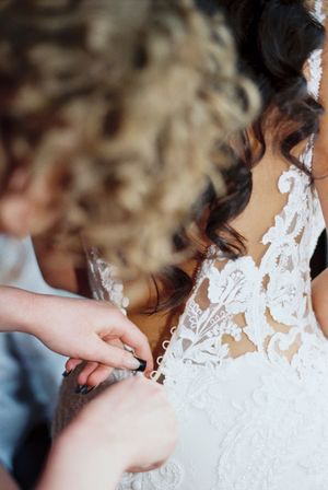 Newlyweds sharing a romantic kiss while wearing elegant wedding attire with delicate lace details.