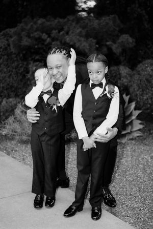 Young children in formal attire playfully pose together at a wedding celebration.