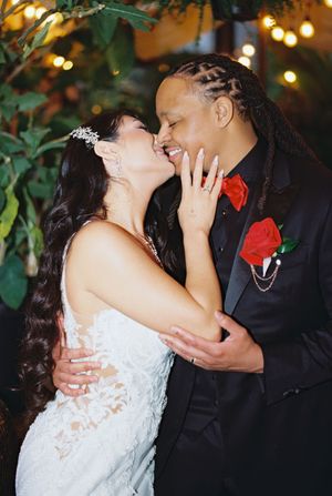 A romantic wedding moment shared between newlyweds under twinkling lights.