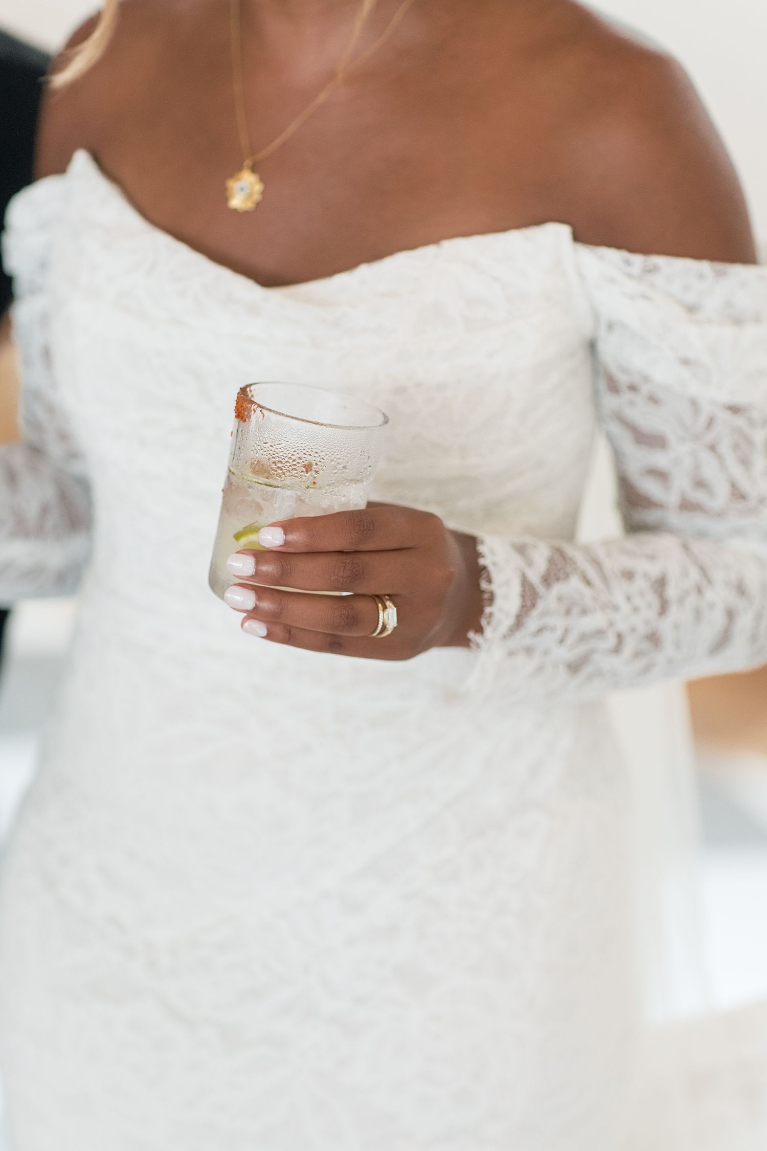 Close-up detail shots of a white lace wedding dress showing off-shoulder neckline and intricate embellishments.