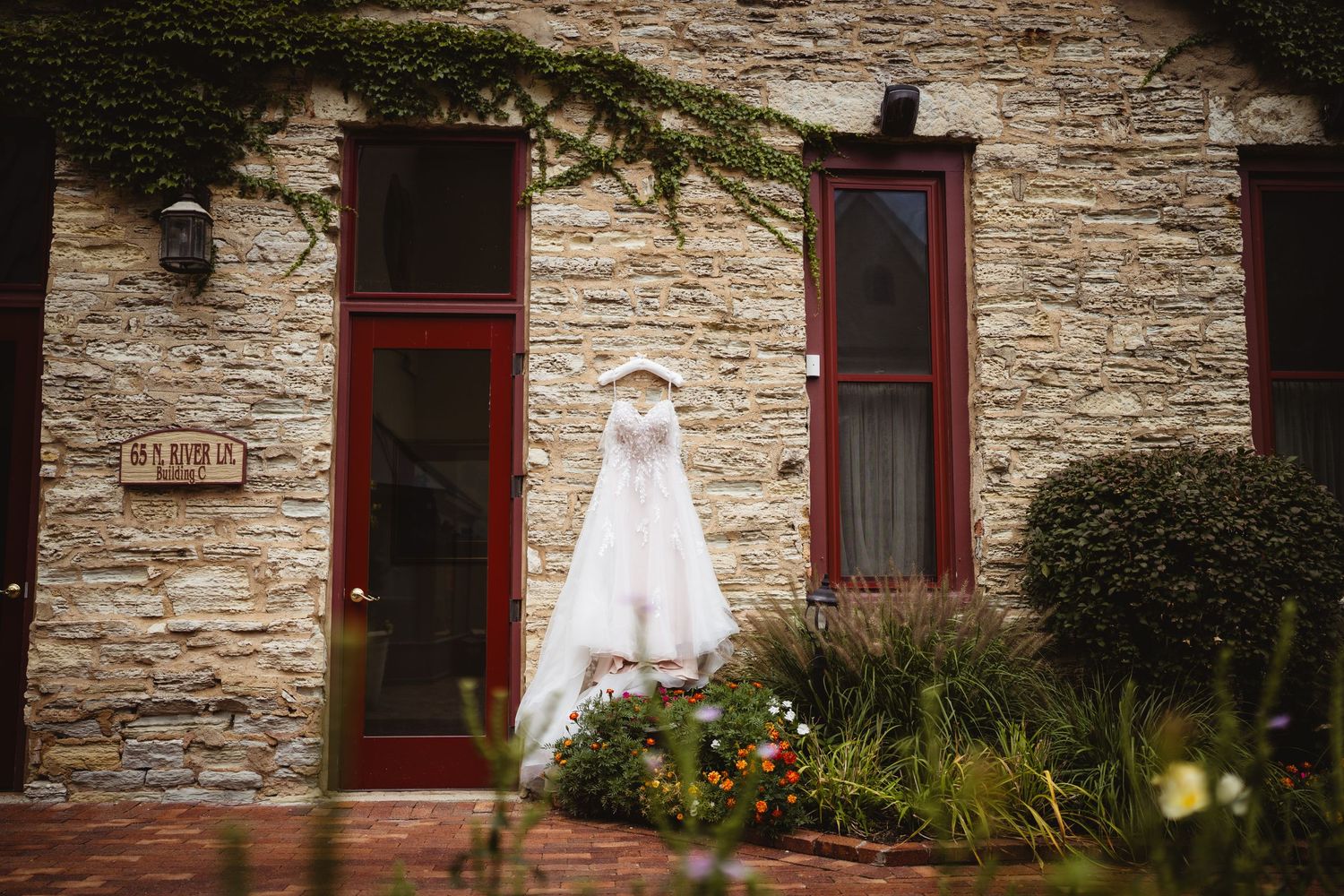 Stone wall exterior of a rustic building with red-trimmed windows and decorative floral accents.