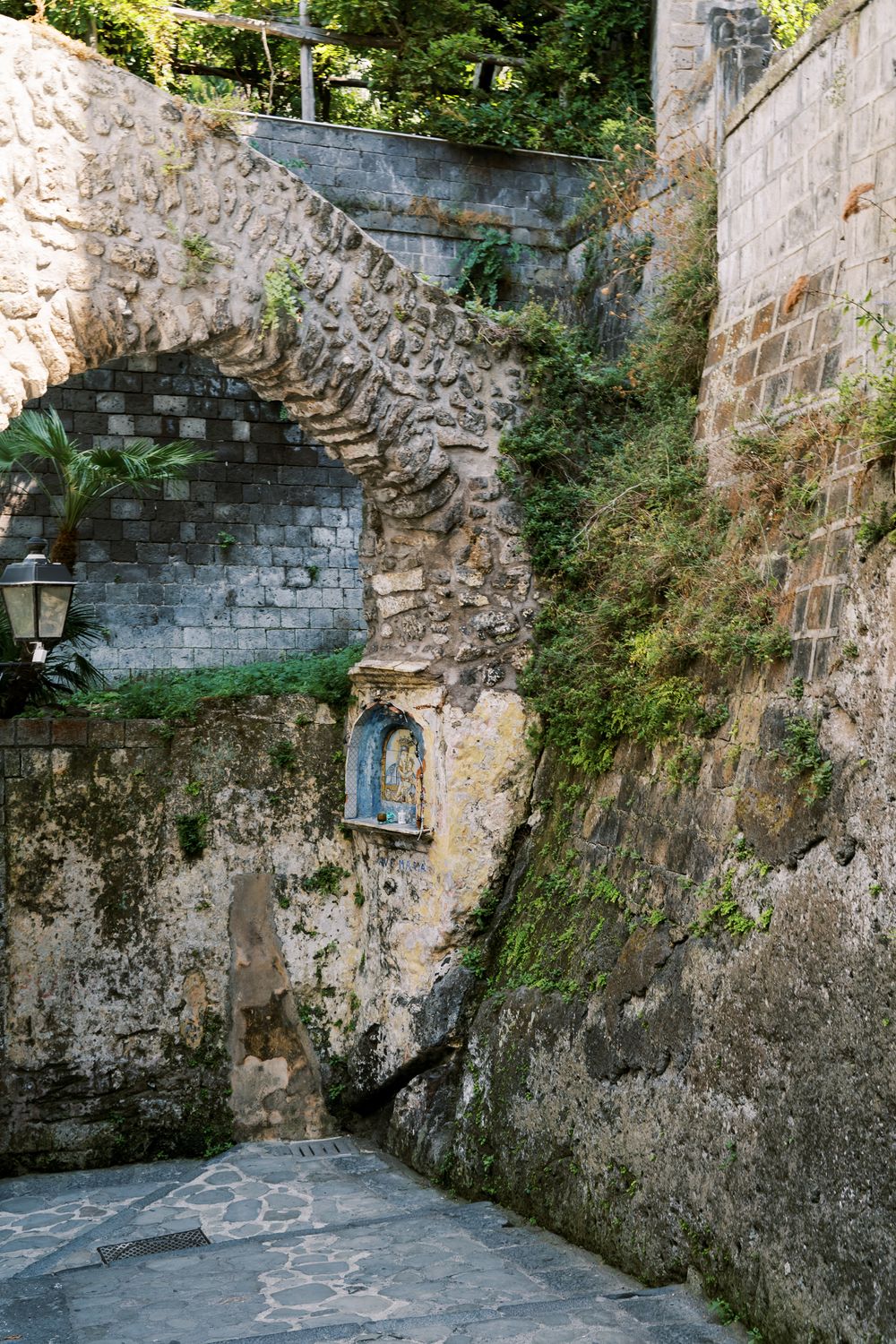 Historic stone passageway with curved walls and archways leads through ancient medieval architecture.