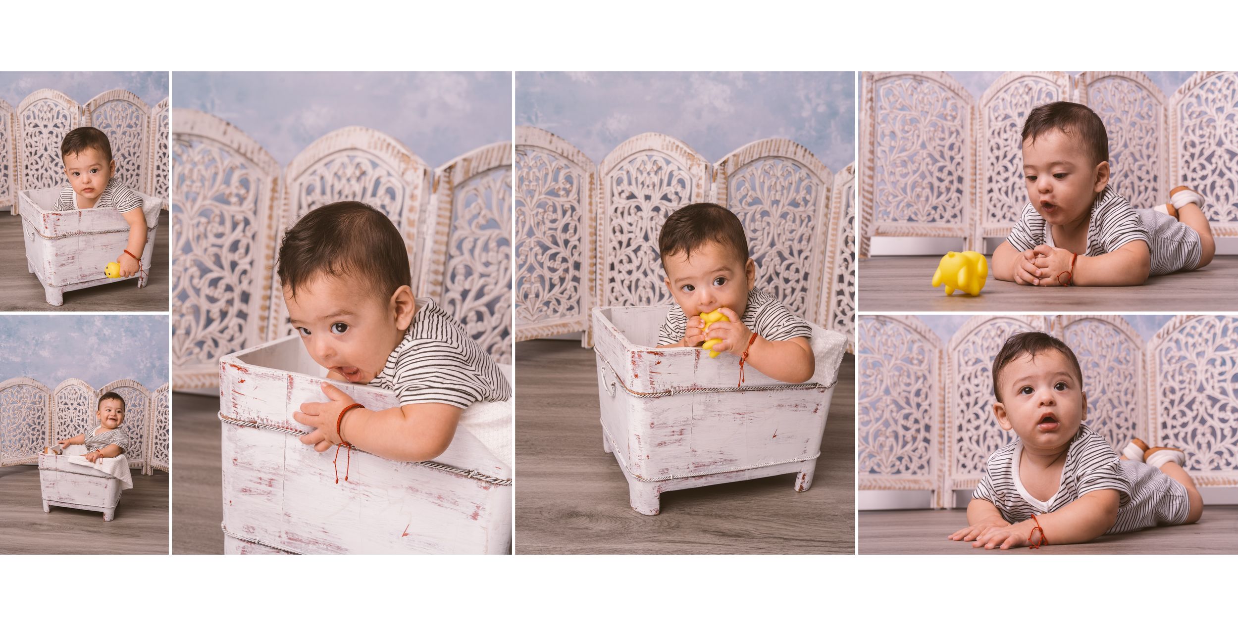 Baby lying on floor with decorative white screens in background during professional photoshoot.