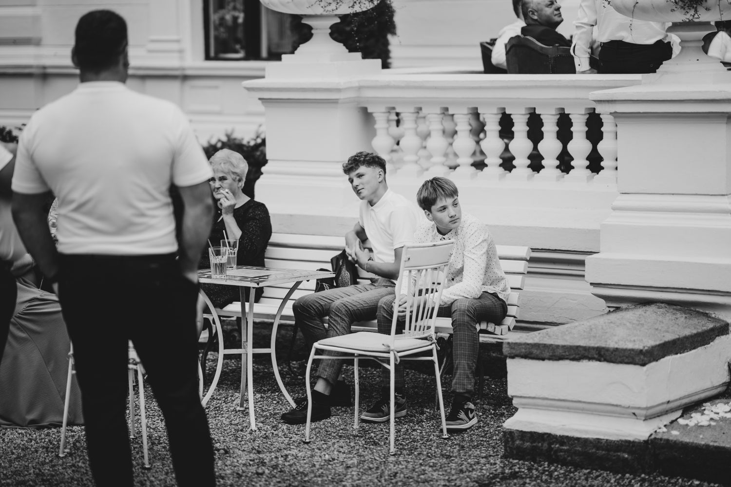 Black and white photo of outdoor wedding reception with guests seated at tables.