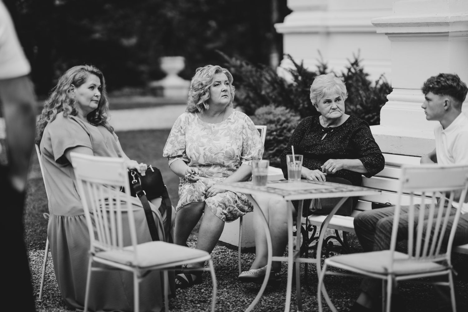 Casual outdoor wedding reception with guests enjoying conversation at garden tables.