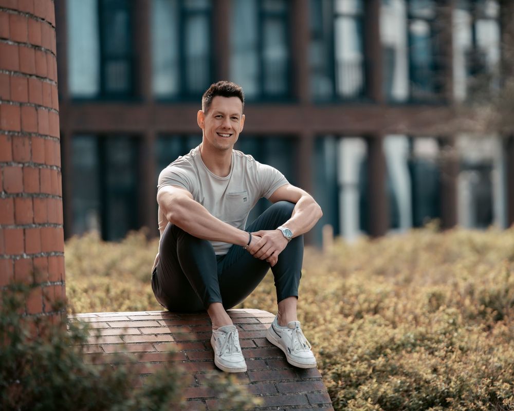 Urban portrait session featuring relaxed poses against brick wall backdrop.