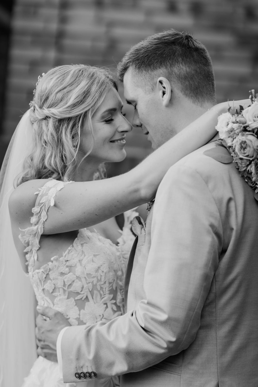 Romantic black and white portrait of newlyweds sharing intimate moment.