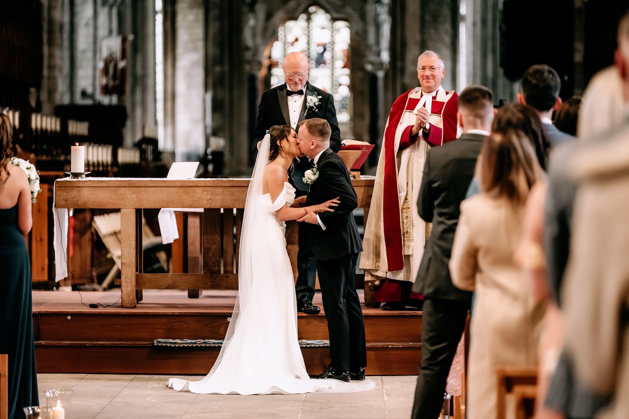 Intimate wedding ceremony moment inside a grand cathedral with ornate architecture.