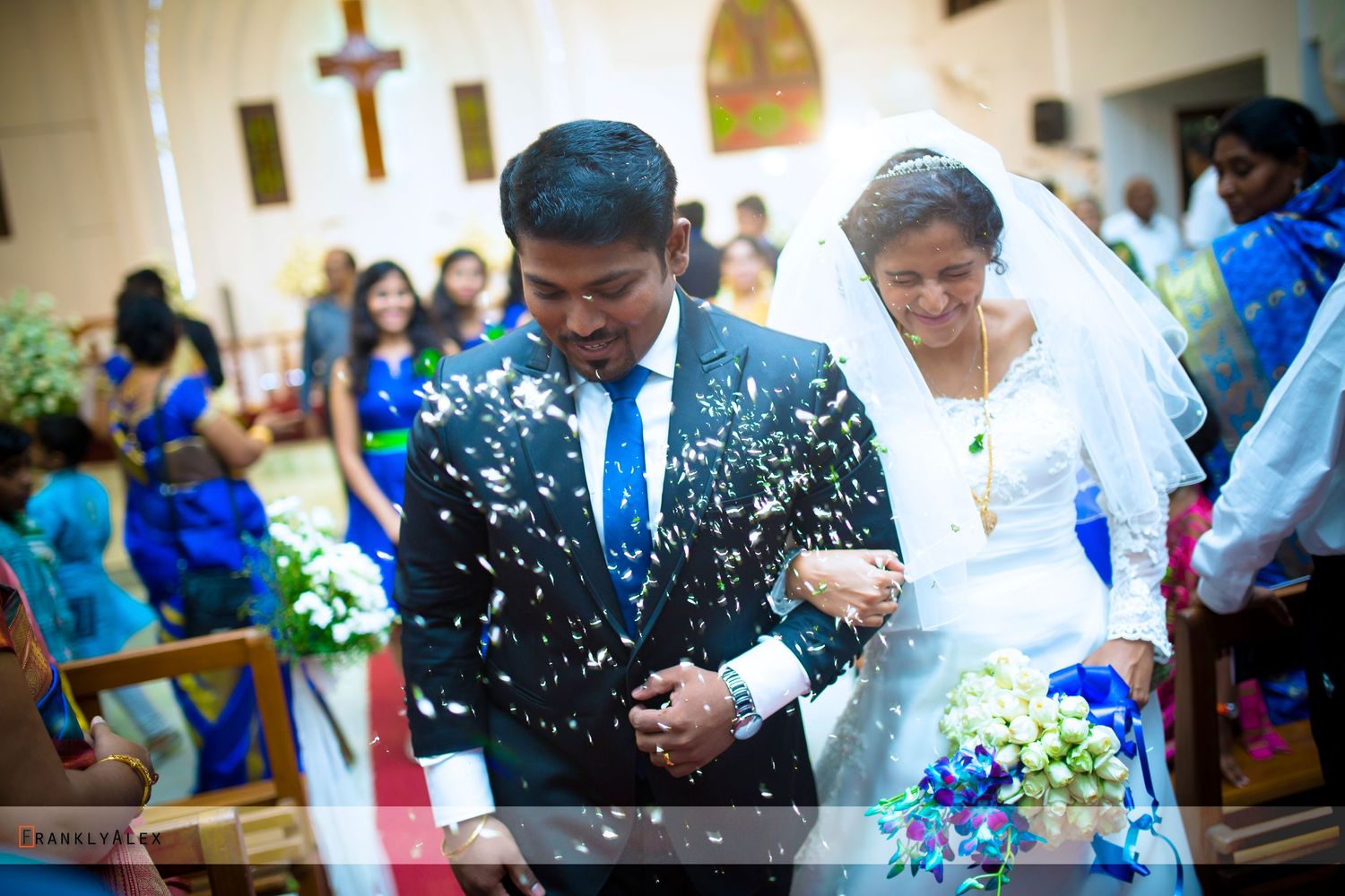 A joyful wedding ceremony in a church with confetti falling around the couple.