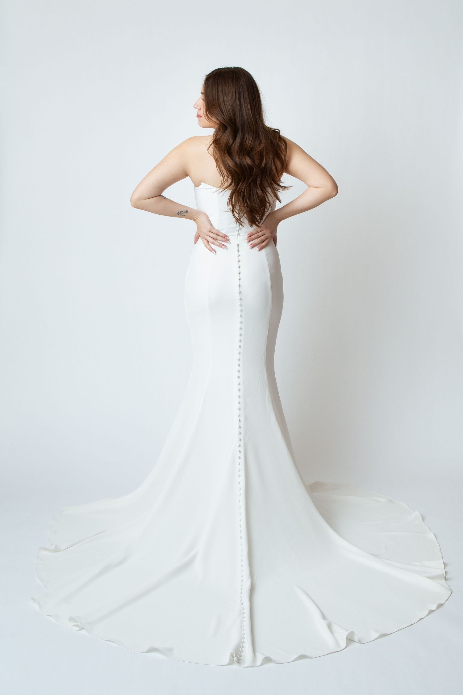 Full length photo of a bride in a form fitting wedding dress from the Grace and Joanie Collection by Celebrations Bridal and Prom NBTX