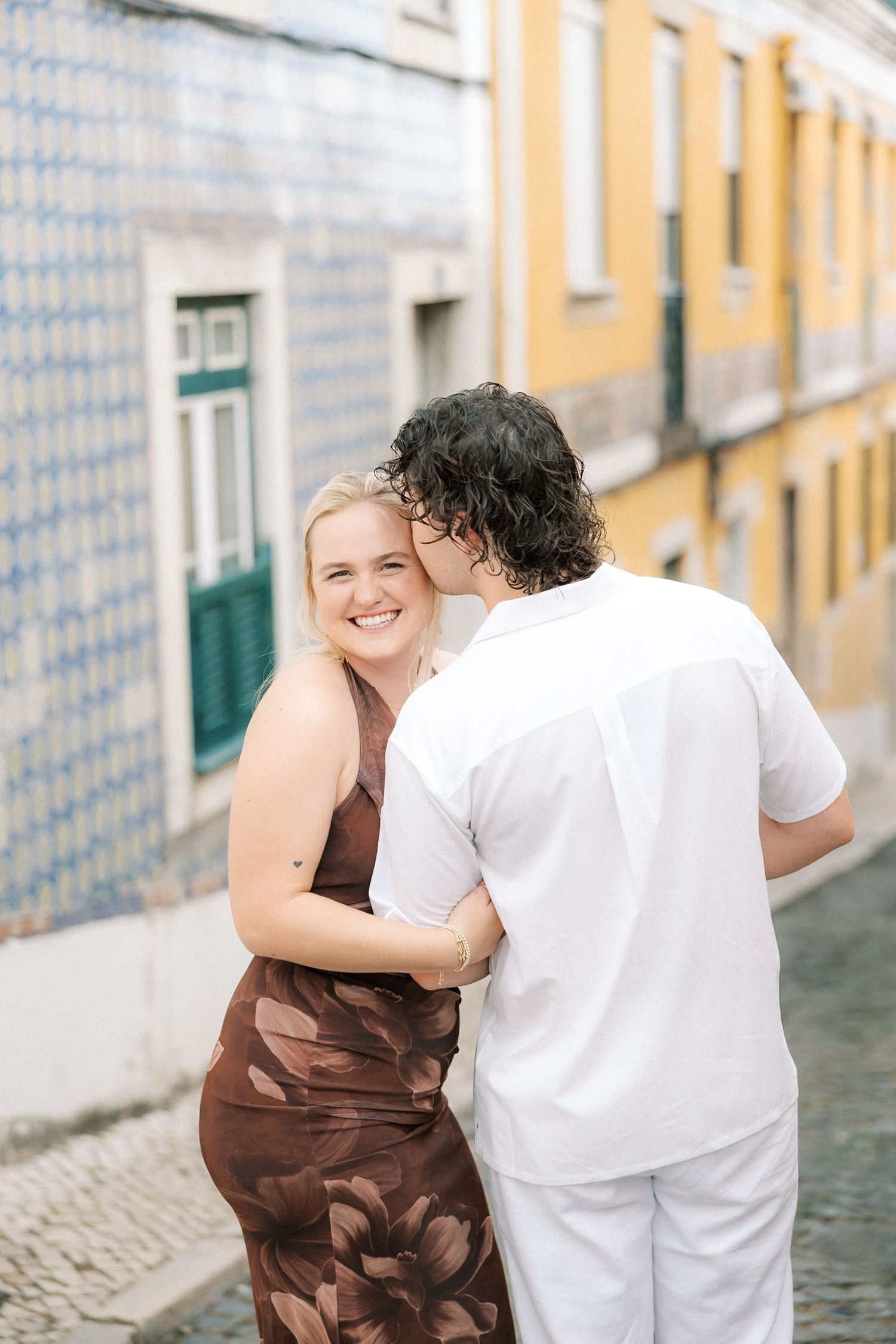 Couple embracing during a romantic Lisbon city session before their Portugal wedding