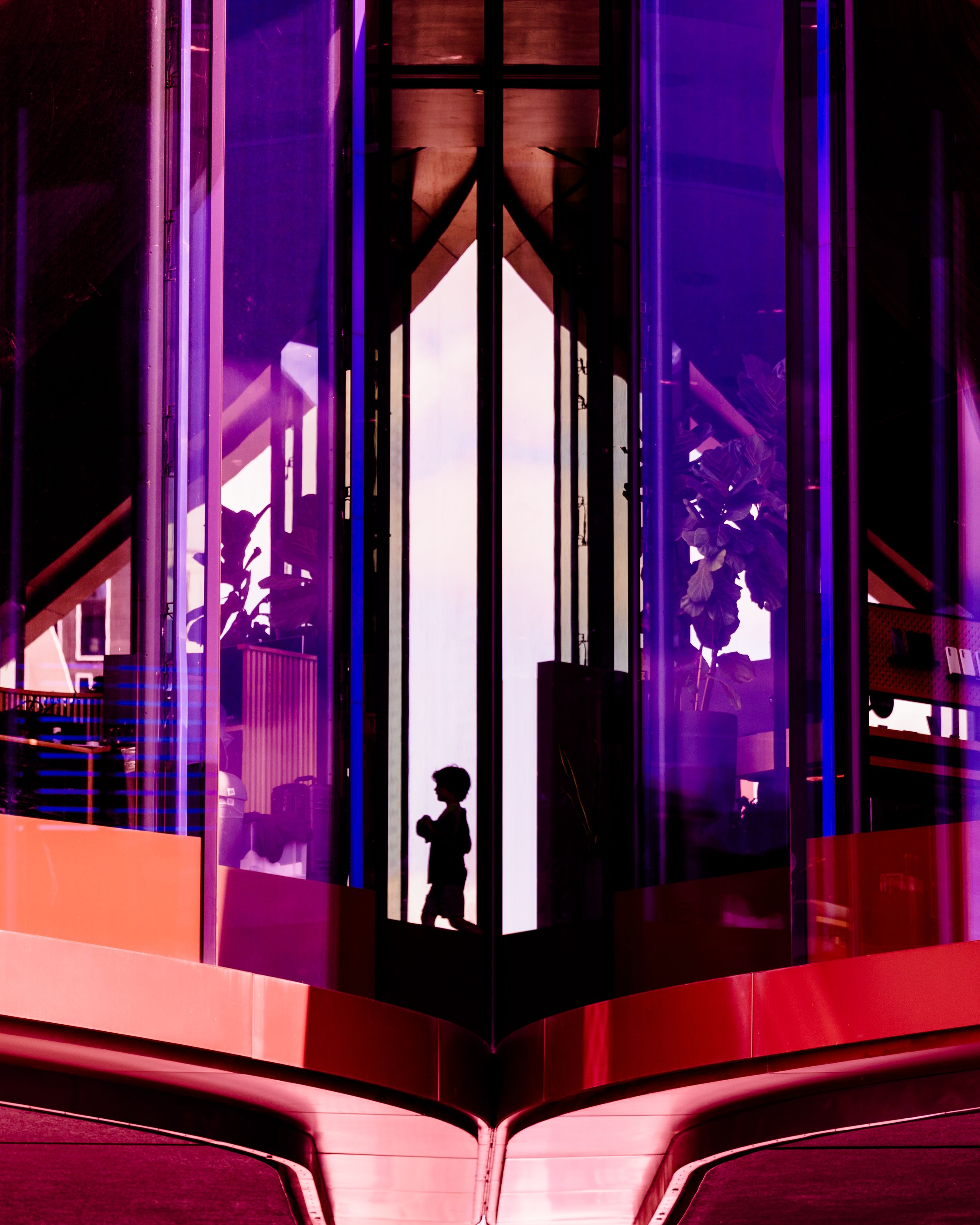 Abstract urban photo of a reflective purple glass building with a silhouetted figure