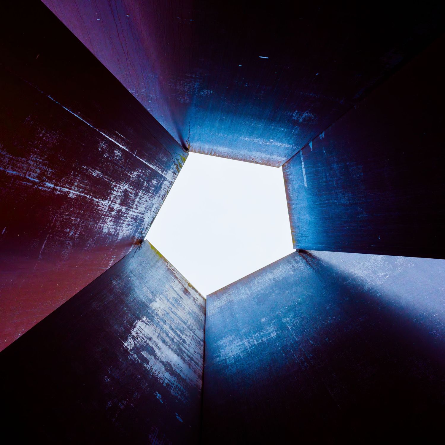 Dramatic upward view of a geometric pentagon-shaped skylight, architecture photography