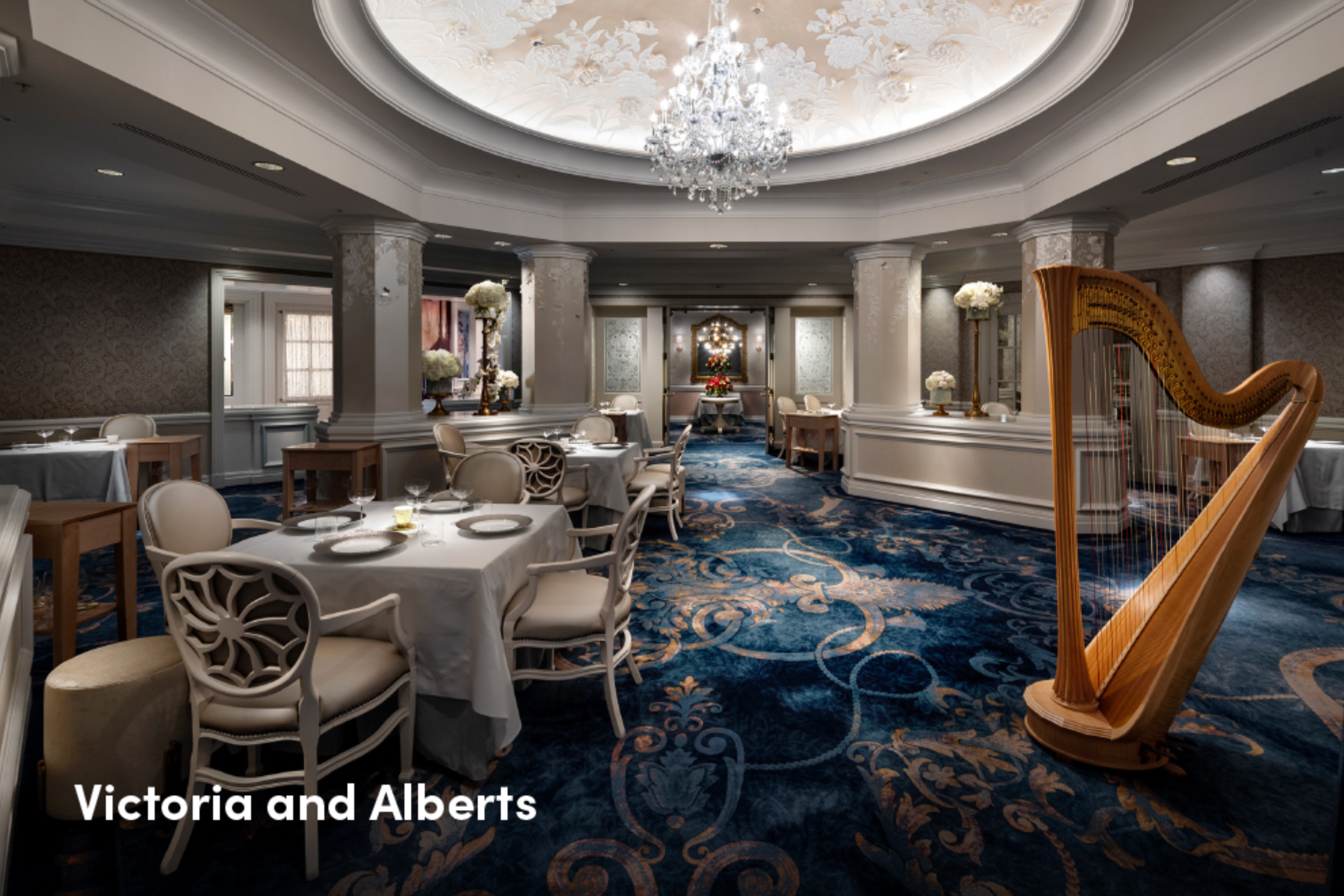 Elegant dining room interior with crystal chandeliers and ornate ceiling details at Victoria and Albert's.