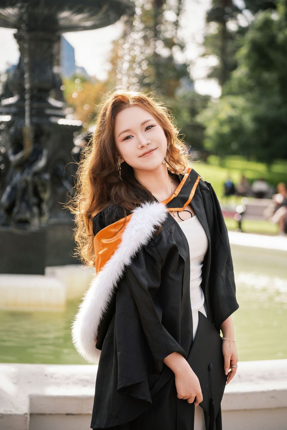 Stunning outdoor graduation photography featuring a proud student posing by the iconic Albert Park fountain.